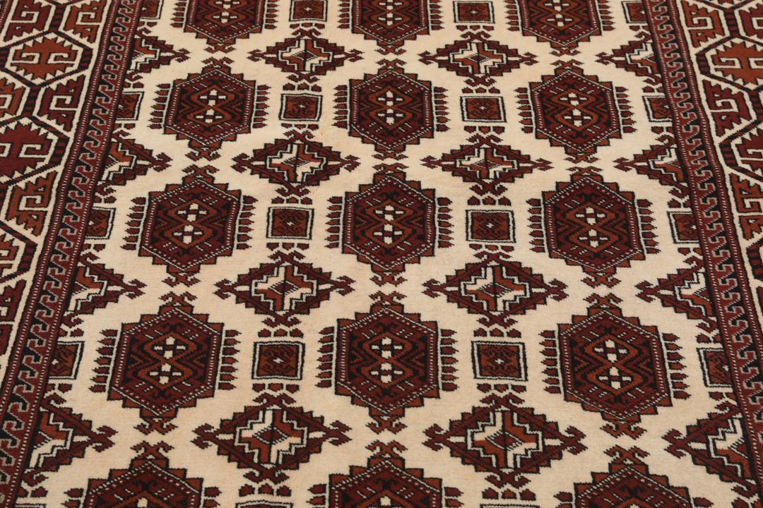 Met de hand geknoopt Turkaman-tapijt uit het Midden-Oosten in dieprode en beige tinten.