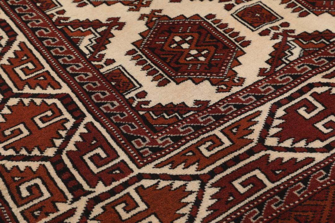 Met de hand geknoopt Turkaman-tapijt uit het Midden-Oosten in dieprode en beige tinten.