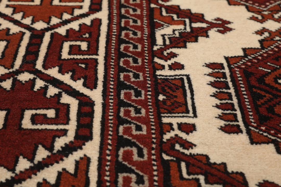 Met de hand geknoopt Turkaman-tapijt uit het Midden-Oosten in dieprode en beige tinten.
