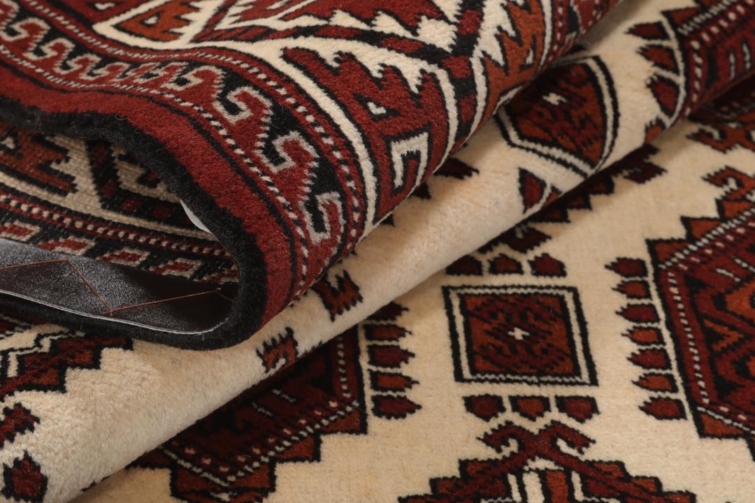 Met de hand geknoopt Turkaman-tapijt uit het Midden-Oosten in dieprode en beige tinten.
