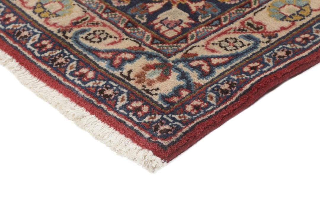 A hand-knotted red Mashad rug featuring a traditional floral medallion design