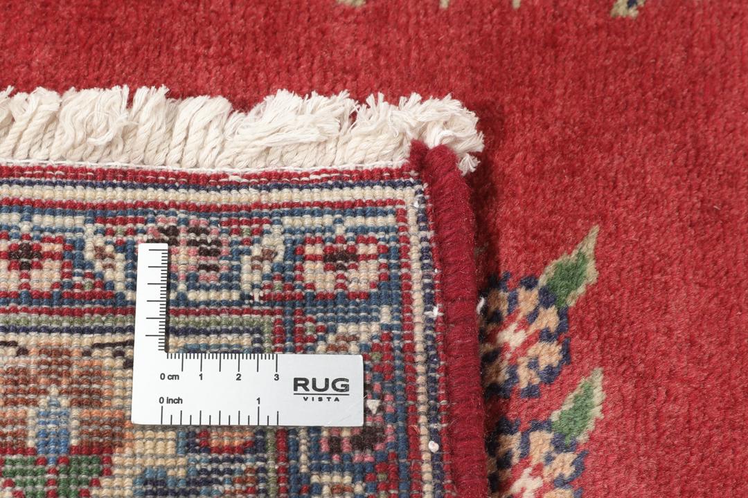 A hand-knotted red Mashad rug featuring a traditional floral medallion design
