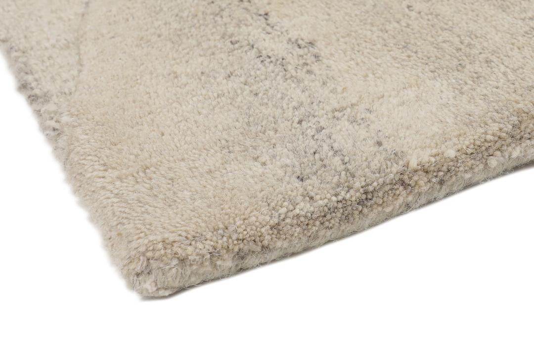 Een modern wollen tapijt in bruin en beige met een geometrisch cirkelpatroon.