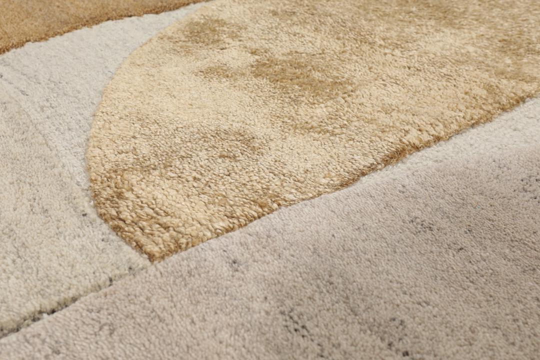 Een modern wollen tapijt in bruin en beige met een geometrisch cirkelpatroon.