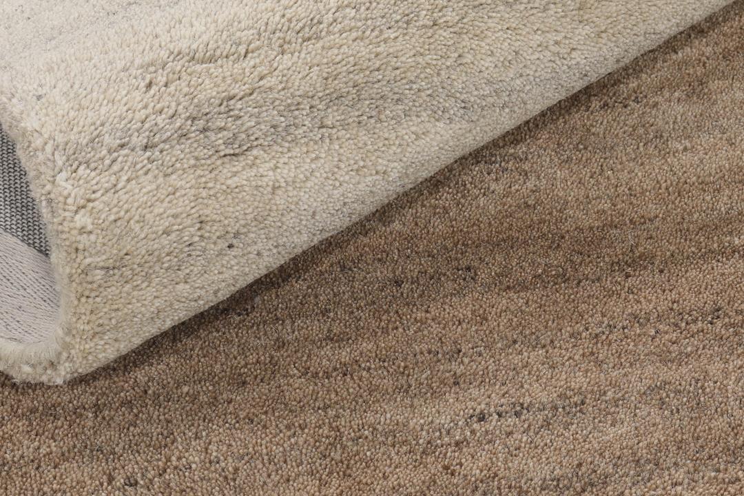 Een modern wollen tapijt in bruin en beige met een geometrisch cirkelpatroon.