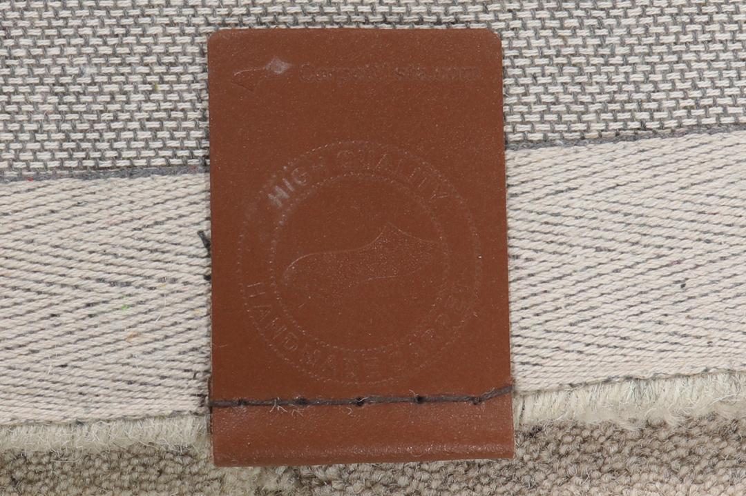 Een modern wollen tapijt in bruin en beige met een geometrisch cirkelpatroon.