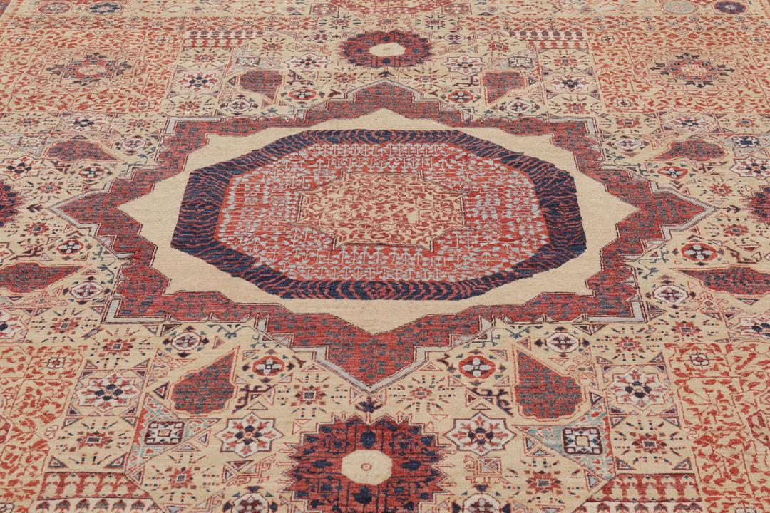 Een rechthoekig Mamluk-tapijt uit Afghanistan met ingewikkelde geometrische en florale patronen in rood en beige.