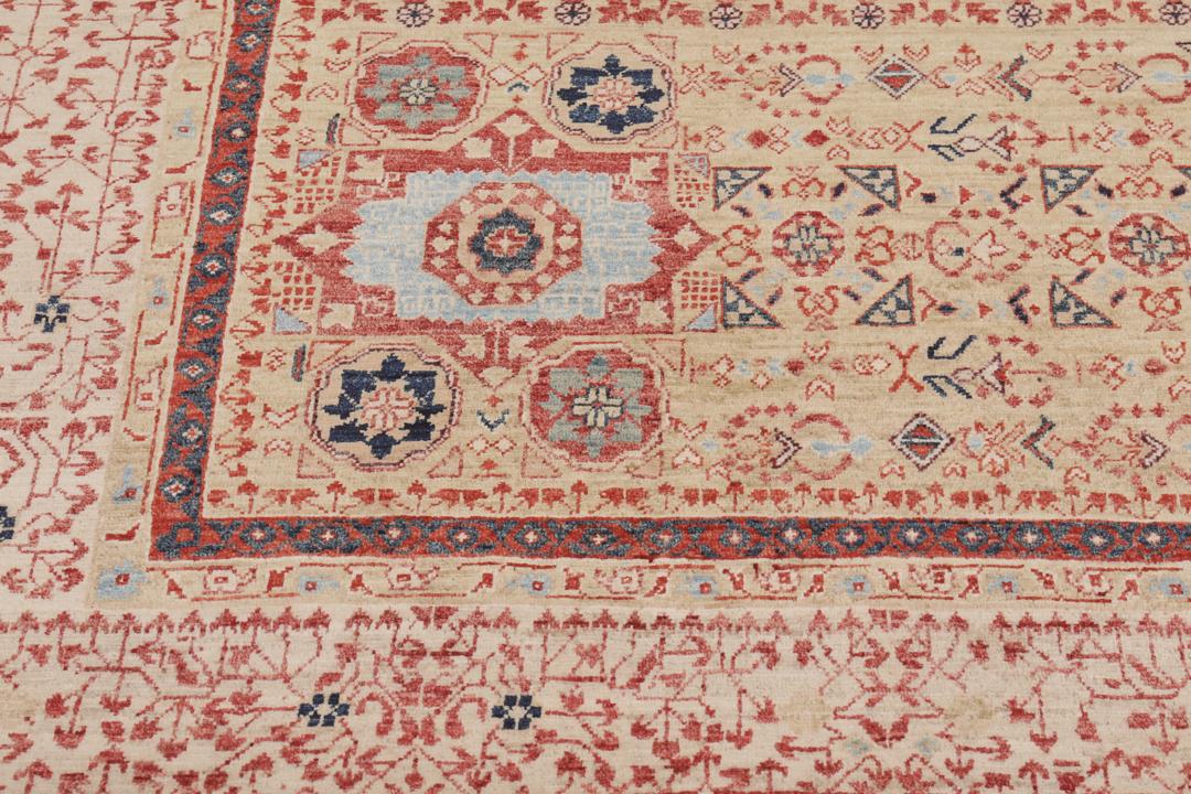 Een rechthoekig Mamluk-tapijt uit Afghanistan met ingewikkelde geometrische en florale patronen in rood en beige.