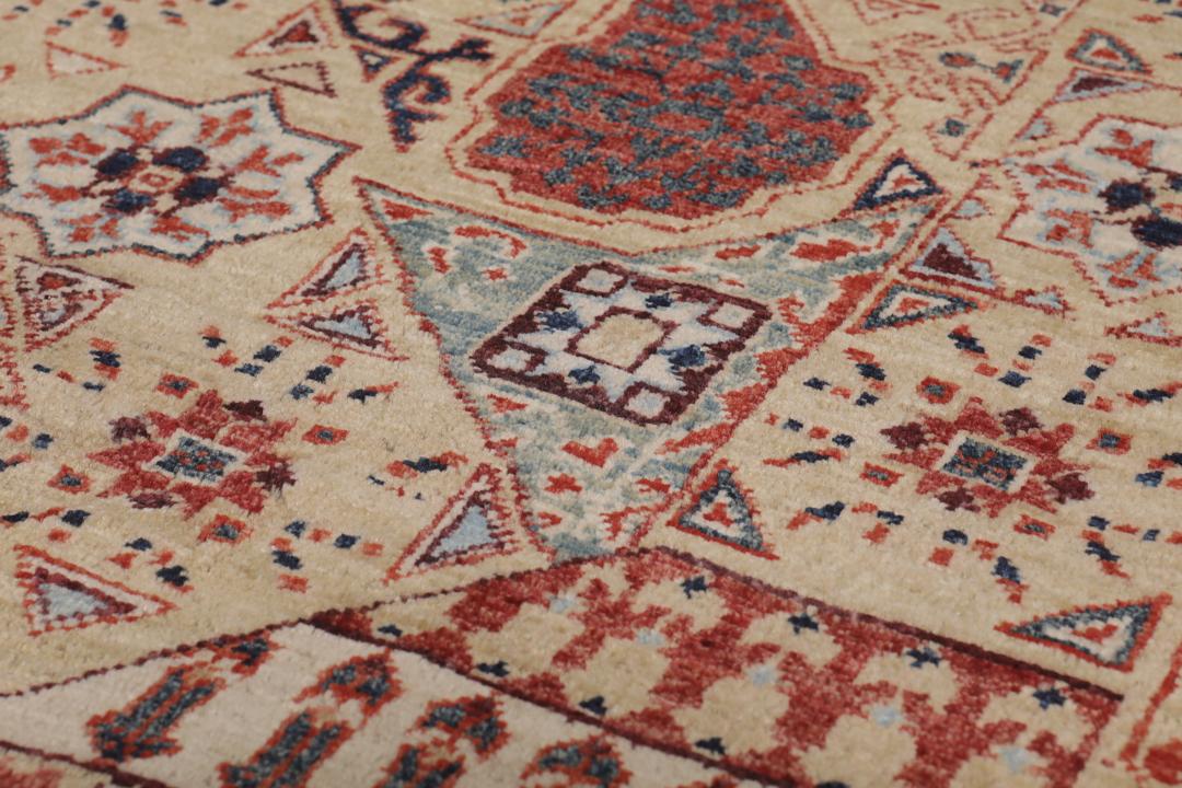 Een rechthoekig Mamluk-tapijt uit Afghanistan met ingewikkelde geometrische en florale patronen in rood en beige.