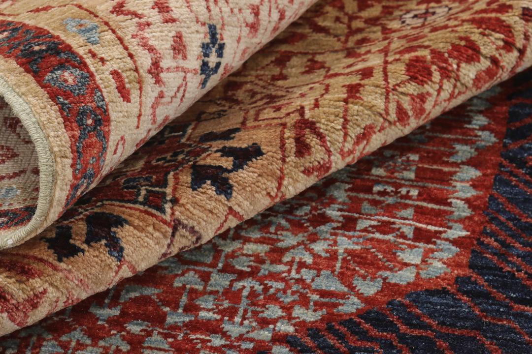 Een rechthoekig Mamluk-tapijt uit Afghanistan met ingewikkelde geometrische en florale patronen in rood en beige.