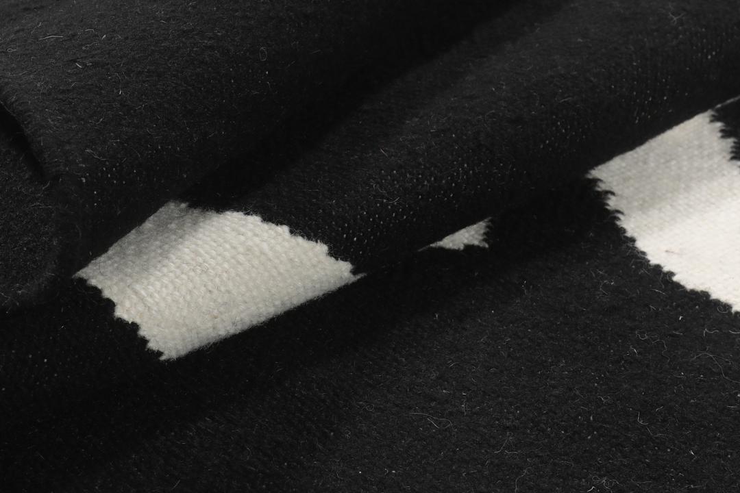 Un tapis noir et blanc avec un motif incurvé