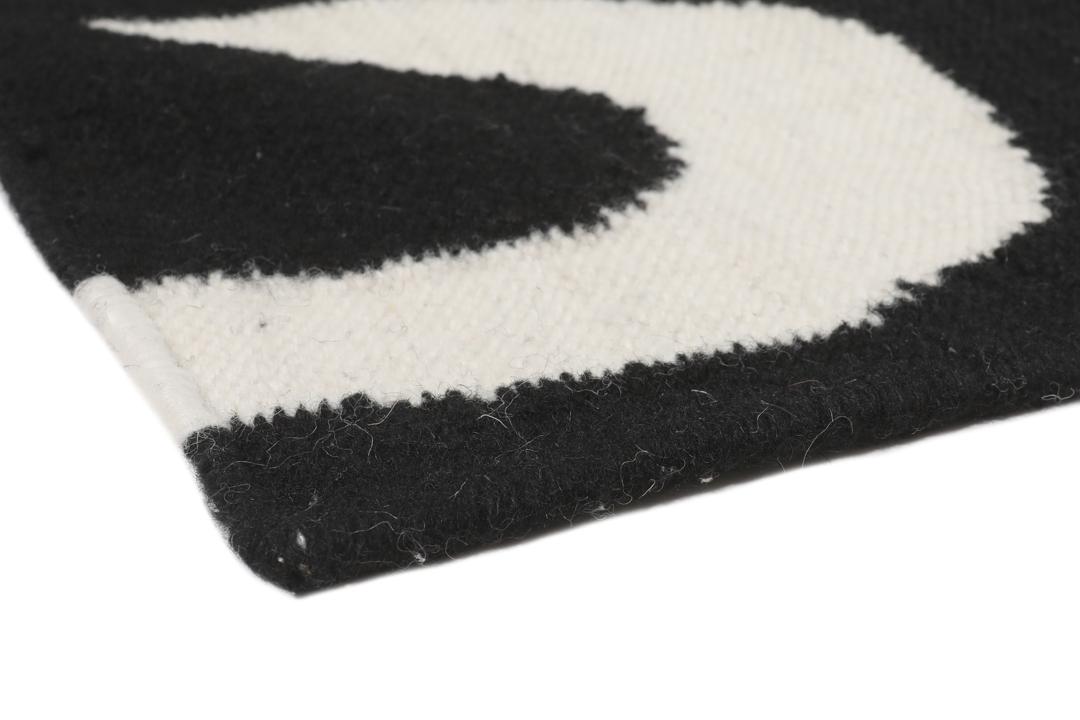 Una alfombra en blanco y negro con un patrón curvo