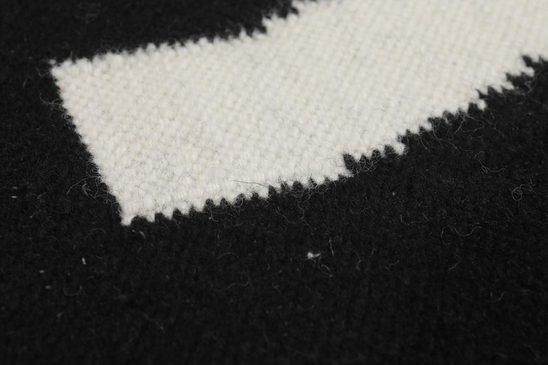 Un tapis noir et blanc avec un motif incurvé