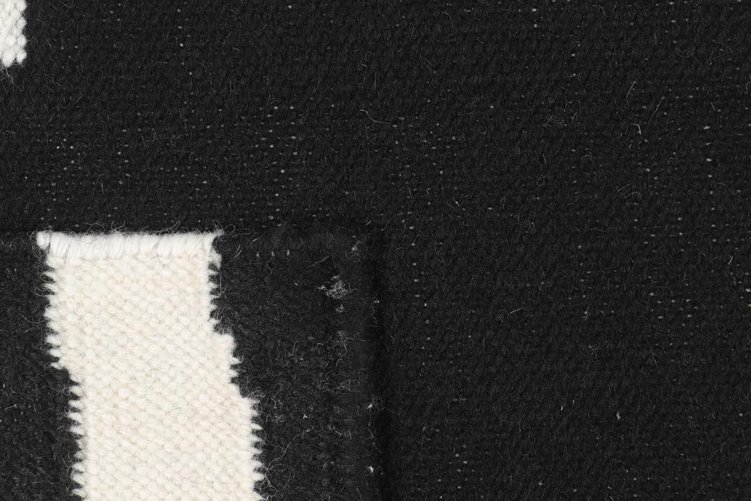 Un tapis noir et blanc avec un motif incurvé