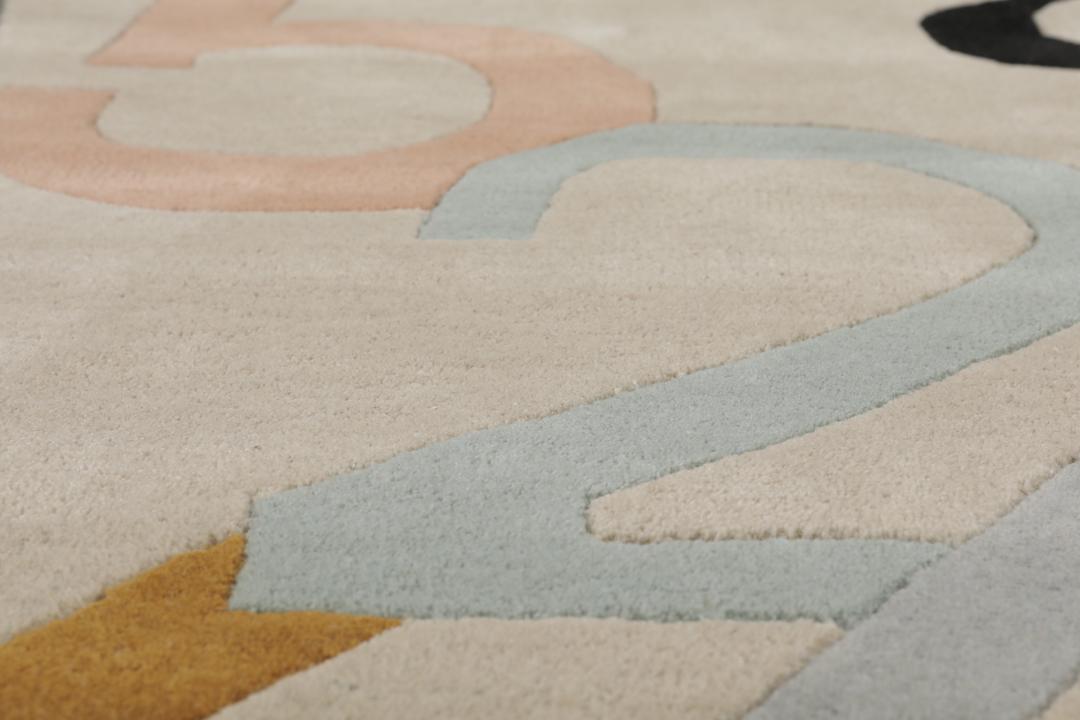 Et beige tæppe med et legende, flerfarvet talmønster.