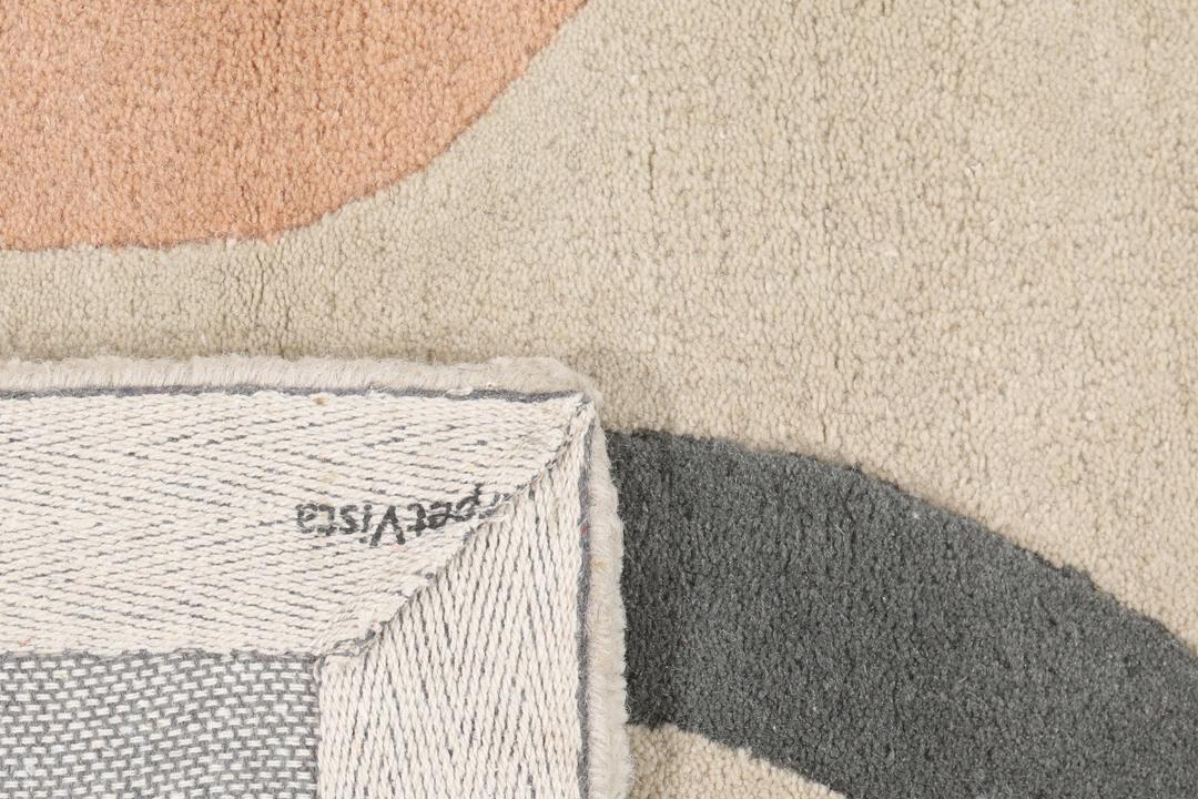 Et beige tæppe med et legende, flerfarvet talmønster.