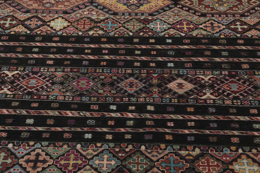 Alfombra afgana anudada a mano con patrones geométricos multicolores sobre fondo negro