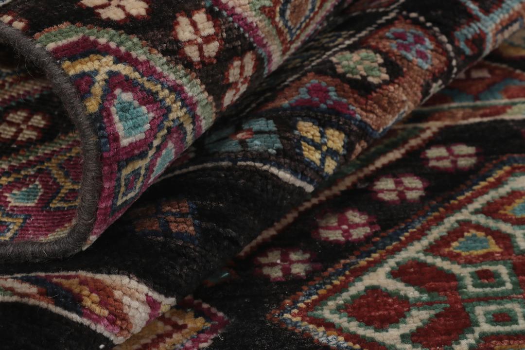 Alfombra afgana anudada a mano con patrones geométricos multicolores sobre fondo negro