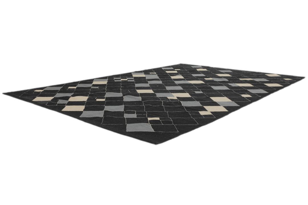 Een modern Afghaans Kelim-tapijt met een geometrisch ruitpatroon in zwart, grijs en beige.