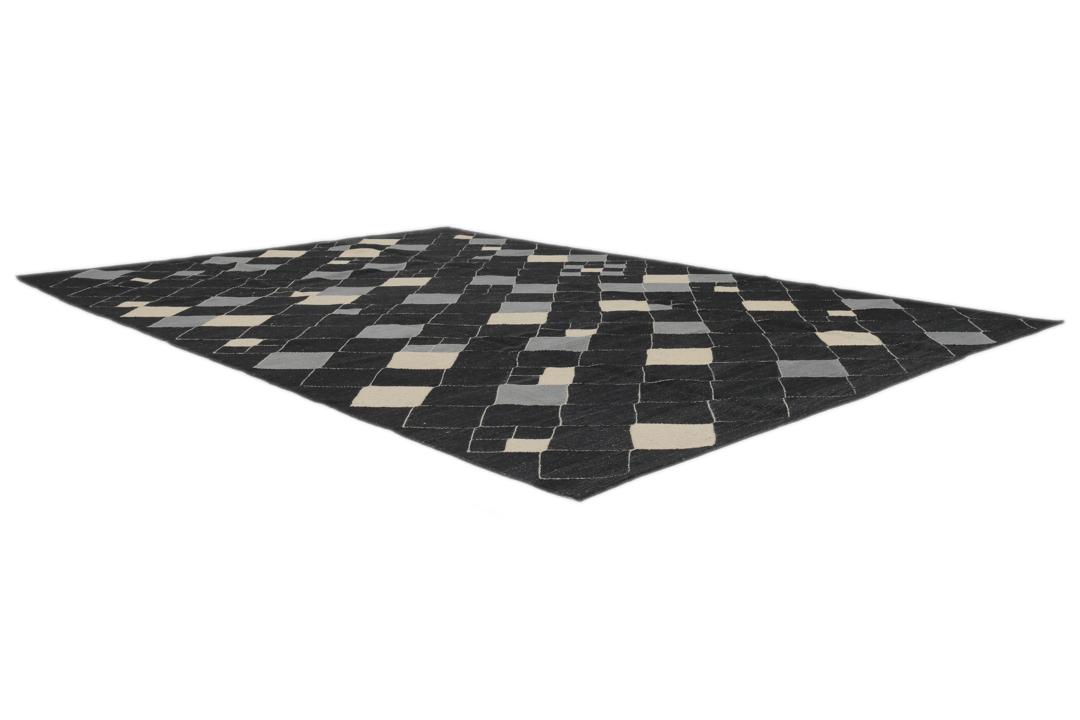Een modern Afghaans Kelim-tapijt met een geometrisch ruitpatroon in zwart, grijs en beige.
