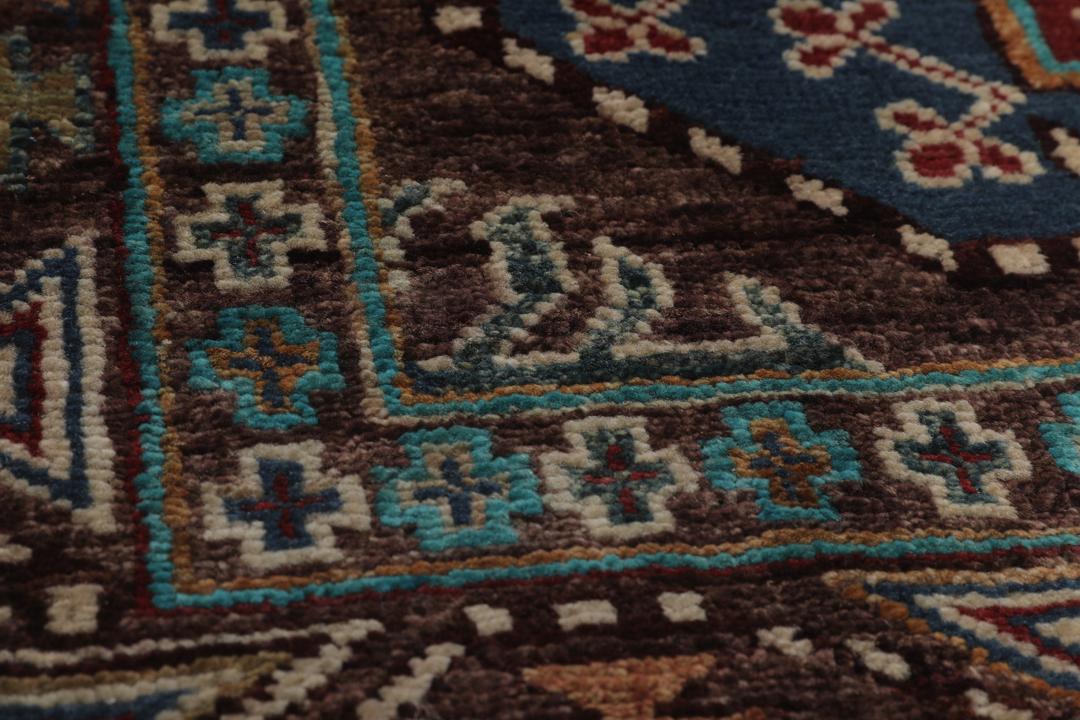Een handgeknoopte Afghaanse loper met een diepbruin veld en kleurrijke geometrische medaillons.