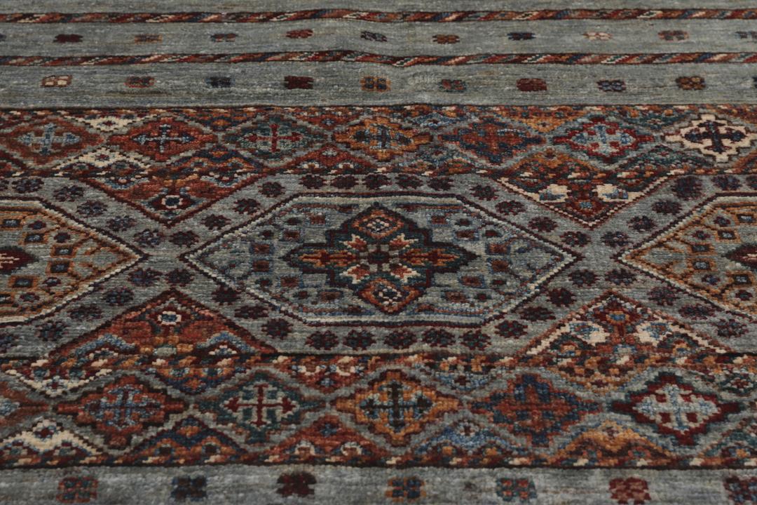 Alfombra afgana anudada a mano en tonos grises y rojos con patrones geométricos