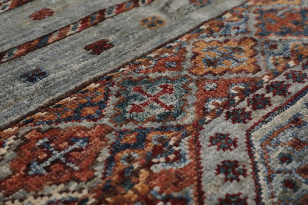 Alfombra afgana anudada a mano en tonos grises y rojos con patrones geométricos