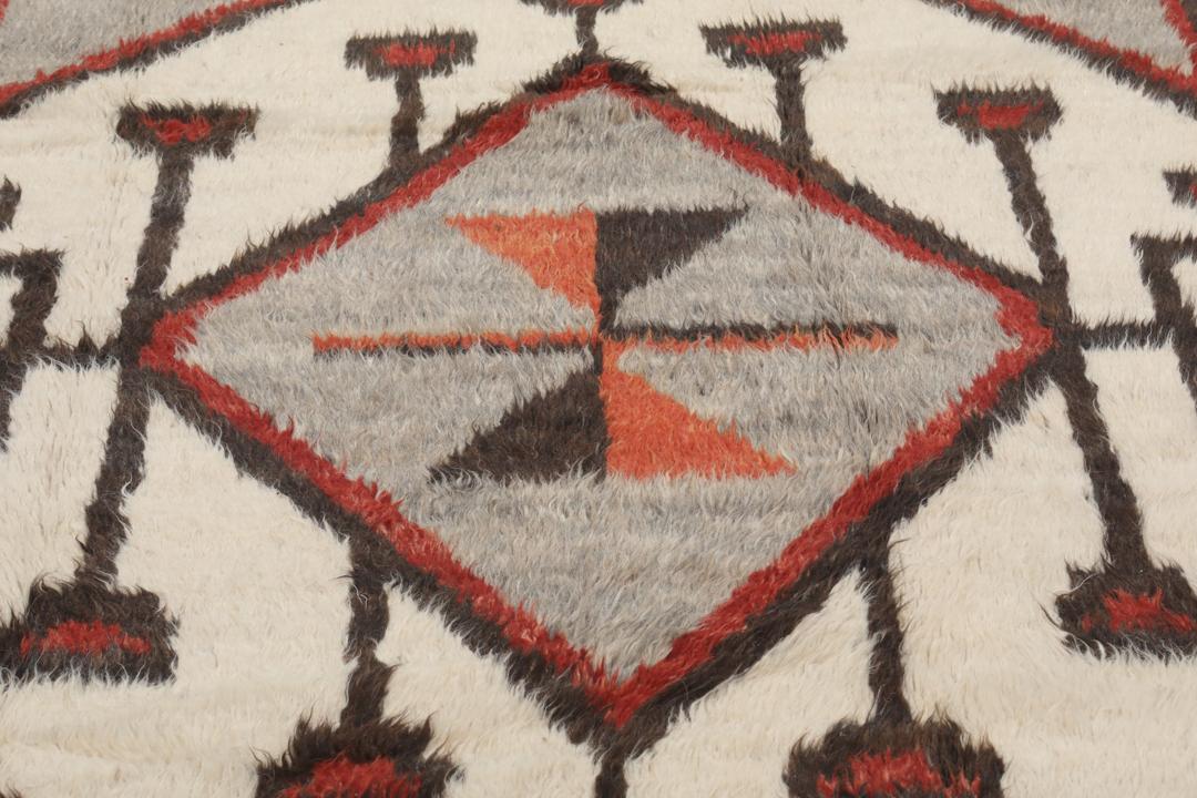 Tapis afghan noué à la main avec des motifs géométriques en rouge, blanc et gris