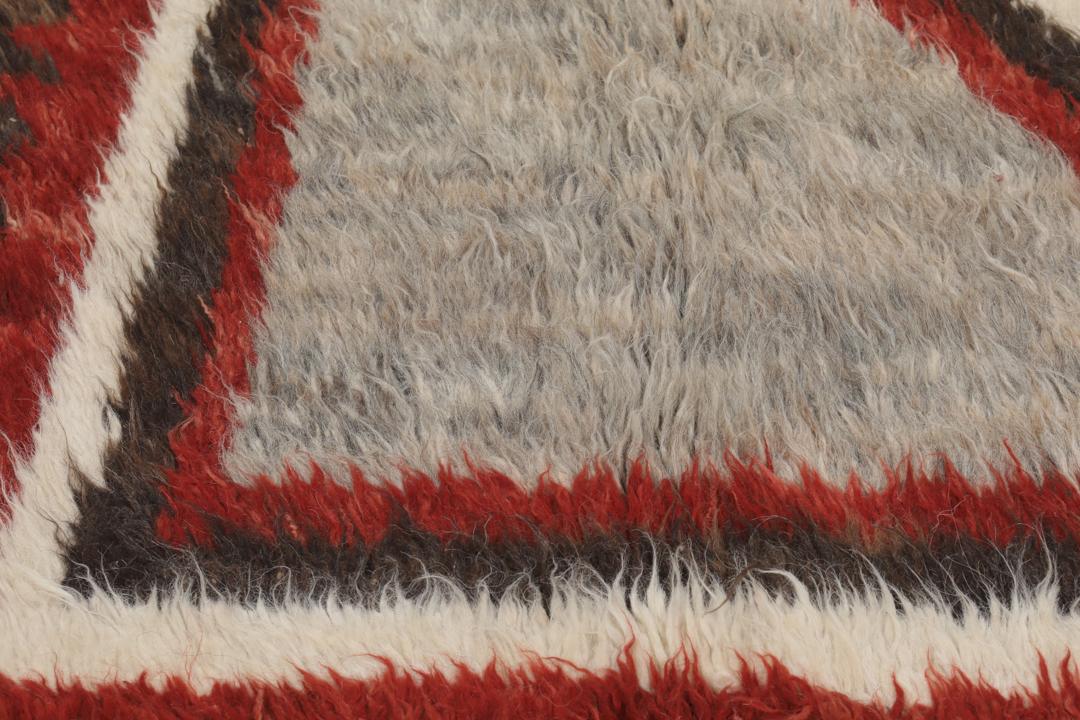 Tapis afghan noué à la main avec des motifs géométriques en rouge, blanc et gris
