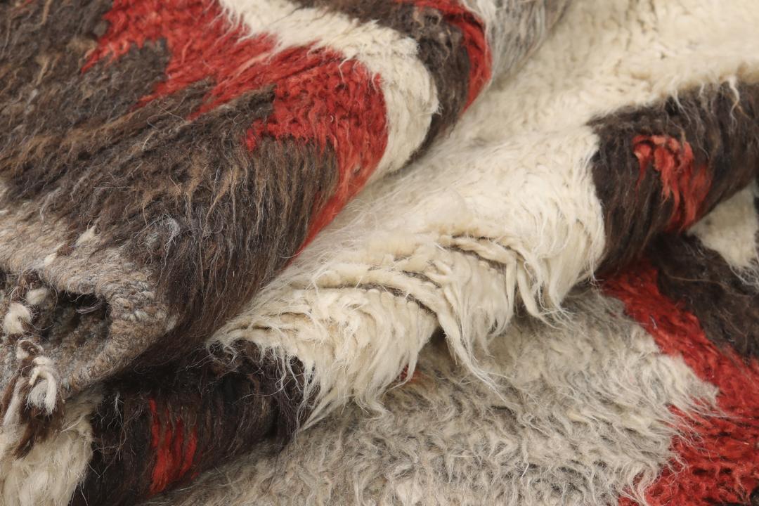 Tapis afghan noué à la main avec des motifs géométriques en rouge, blanc et gris