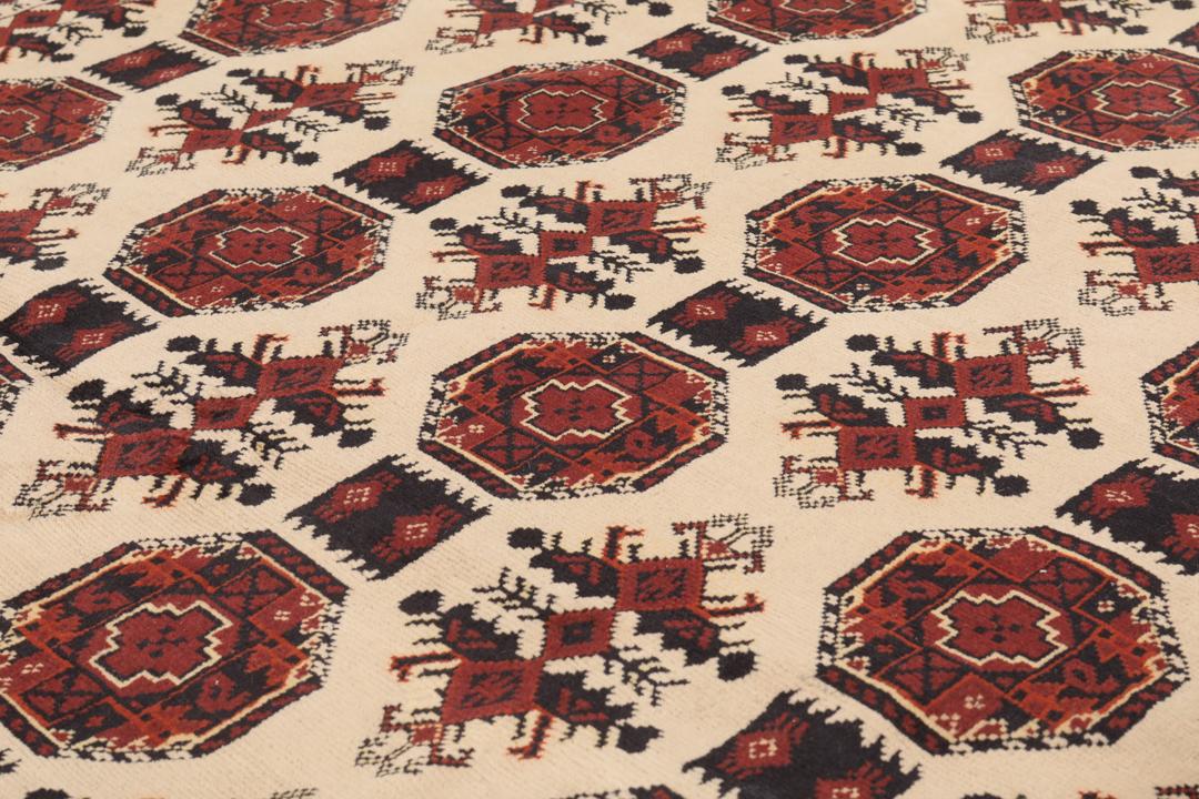 Handgeknoopt Kunduz-tapijt uit Afghanistan in rode en beige tinten.
