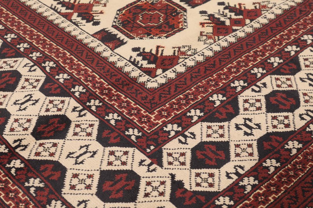 Handgeknoopt Kunduz-tapijt uit Afghanistan in rode en beige tinten.