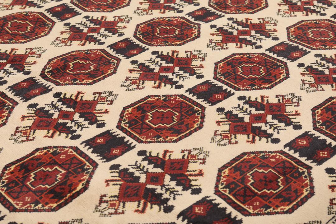 Et håndknyttet Kunduz-tæppe fra Afghanistan i mørkerøde og beige toner.