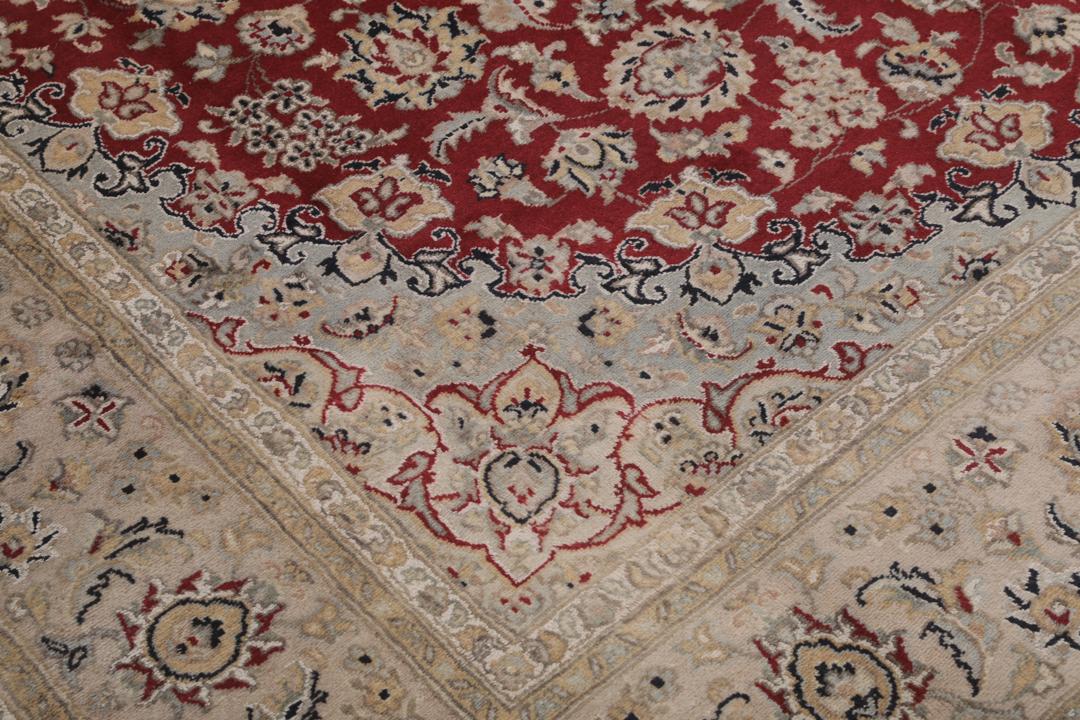 Ręcznie wiązany dywan Tabriz z Indii z czerwonym tłem i dekoracyjnymi wzorami kwiatowymi.