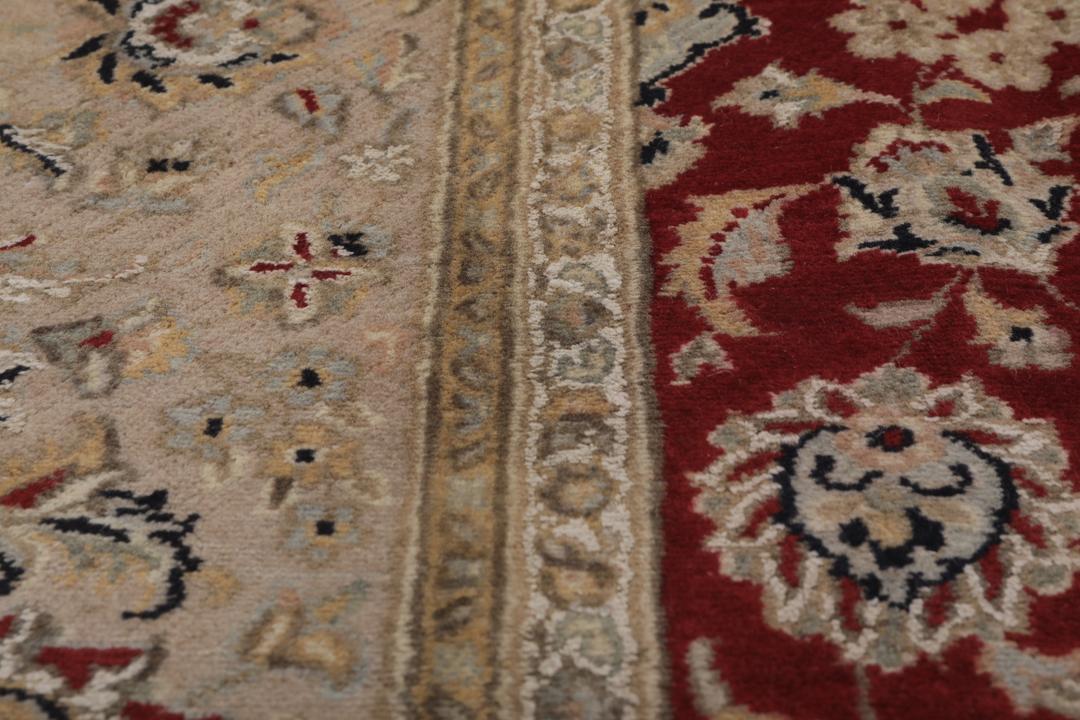 Ręcznie wiązany dywan Tabriz z Indii z czerwonym tłem i dekoracyjnymi wzorami kwiatowymi.
