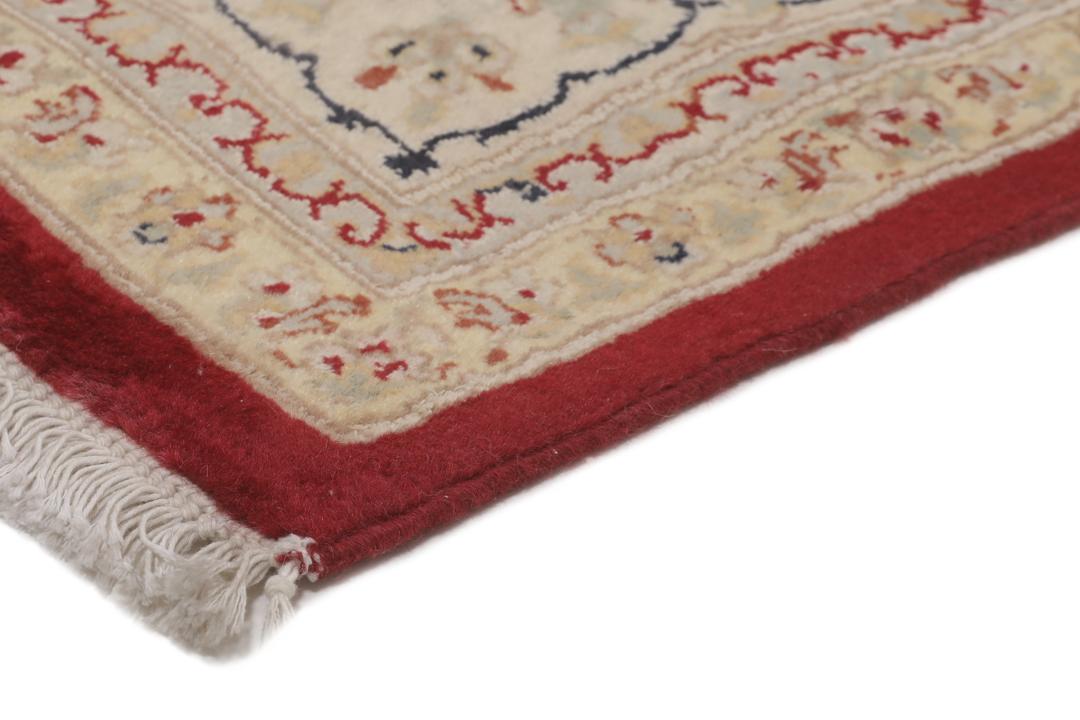 A large hand-knotted Tabriz rug from India with a red field and cream floral border.