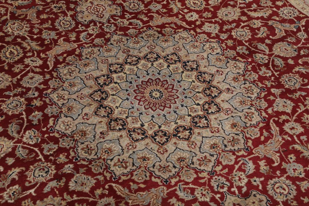 A large hand-knotted Tabriz rug from India with a red field and cream floral border.