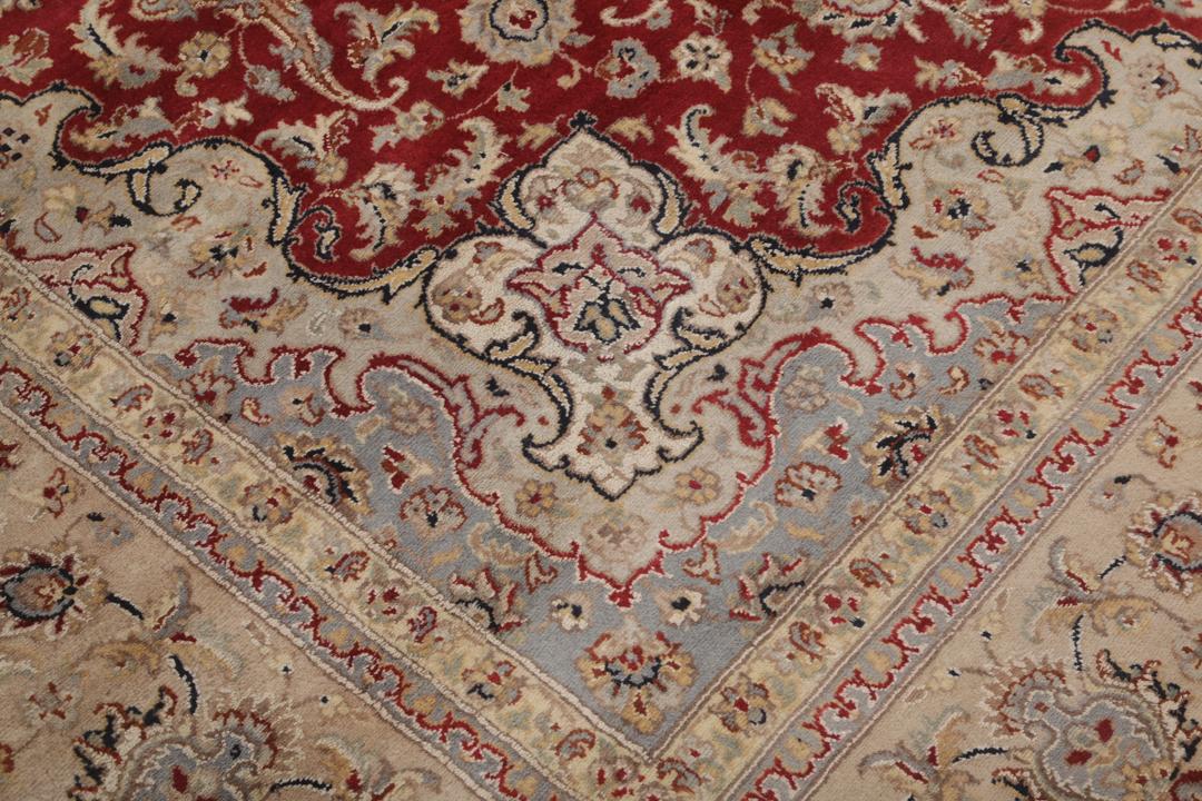 A large hand-knotted Tabriz rug from India with a red field and cream floral border.