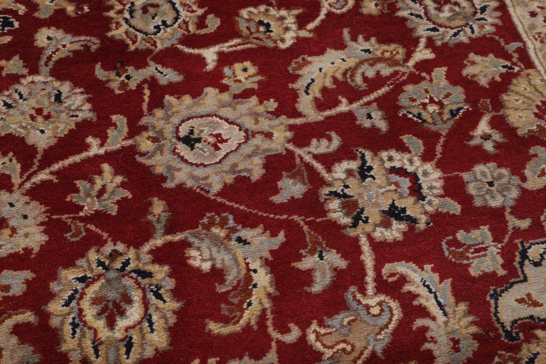 A large hand-knotted Tabriz rug from India with a red field and cream floral border.