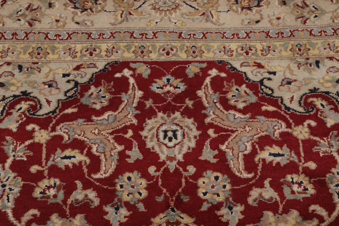 A large hand-knotted Tabriz rug from India with a red field and cream floral border.