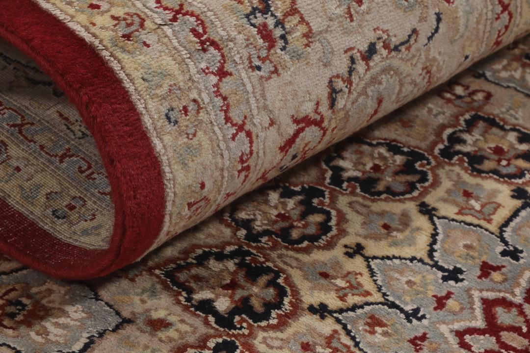 A large hand-knotted Tabriz rug from India with a red field and cream floral border.
