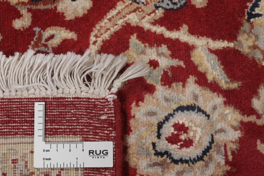 A large hand-knotted Tabriz rug from India with a red field and cream floral border.