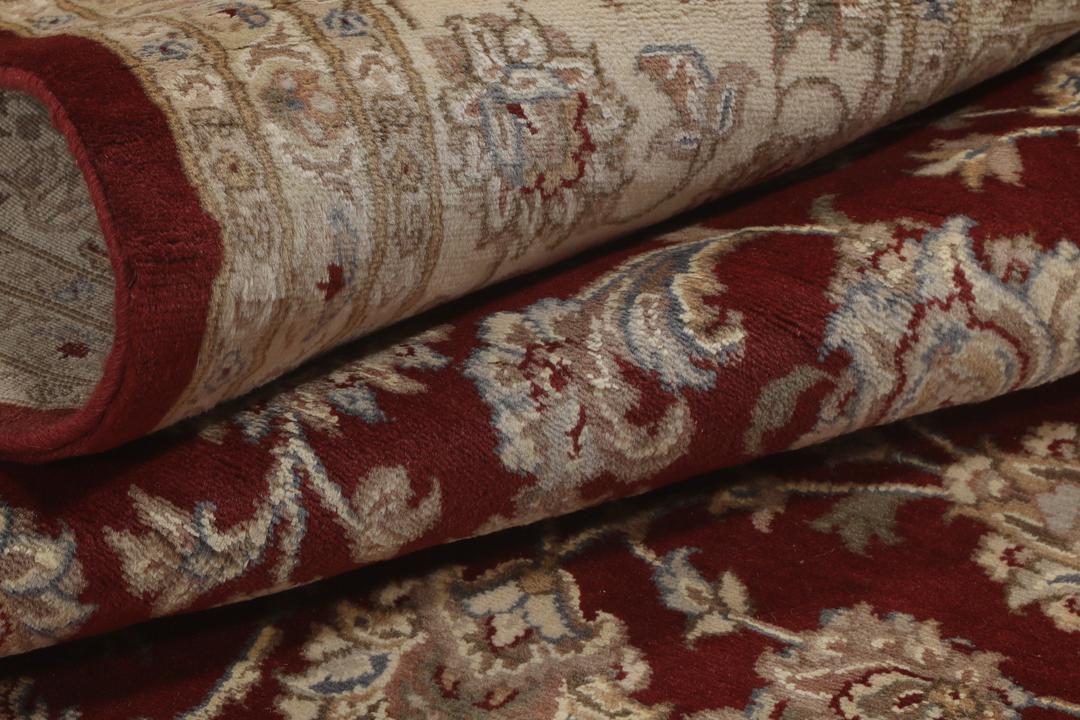 Ręcznie wiązany dywan Tabriz z Indii z czerwonym tłem i misternymi kremowymi wzorami kwiatowymi.