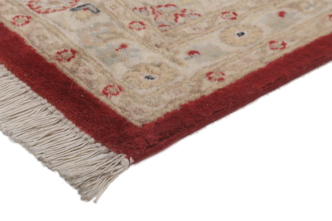 A hand-knotted Tabriz Royal rug from India featuring a central red medallion on a beige field.