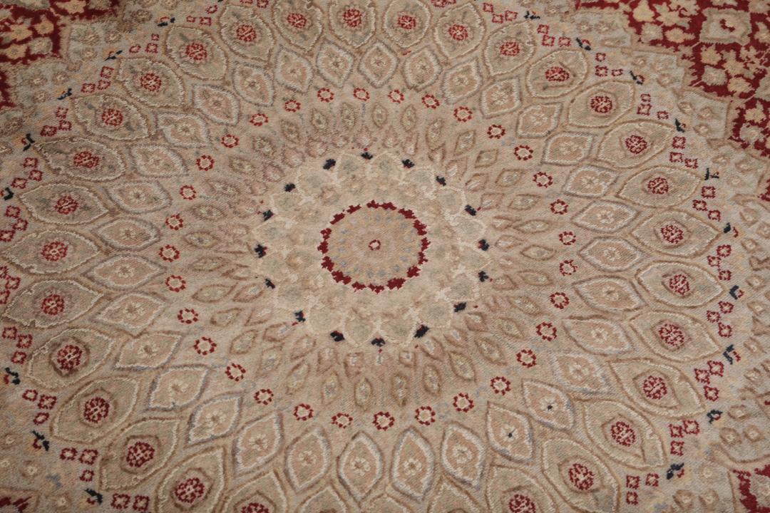 A hand-knotted Tabriz Royal rug from India featuring a central red medallion on a beige field.