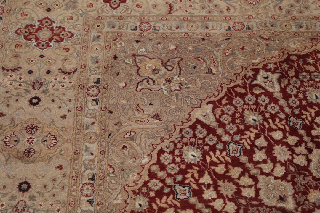 A hand-knotted Tabriz Royal rug from India featuring a central red medallion on a beige field.