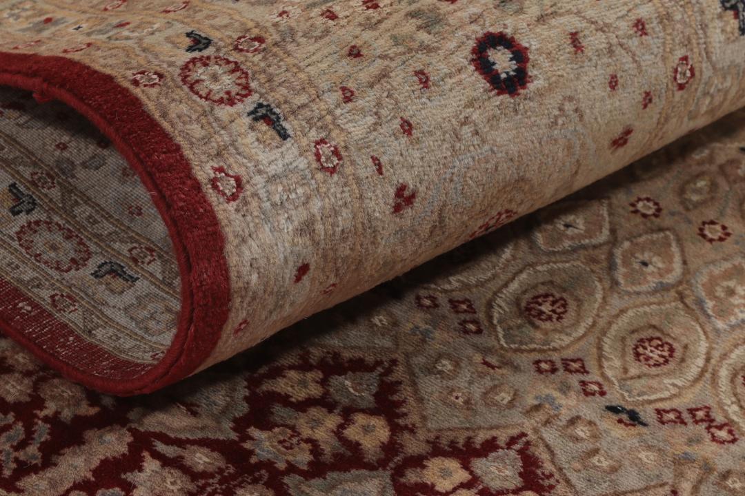 A hand-knotted Tabriz Royal rug from India featuring a central red medallion on a beige field.