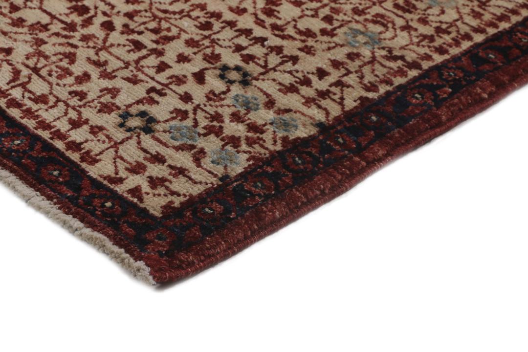 Et håndknyttet Mamluk-tæppe fra Afghanistan i røde og beige nuancer.