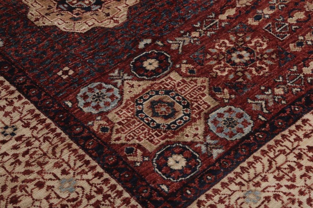 Et håndknyttet Mamluk-tæppe fra Afghanistan i røde og beige nuancer.