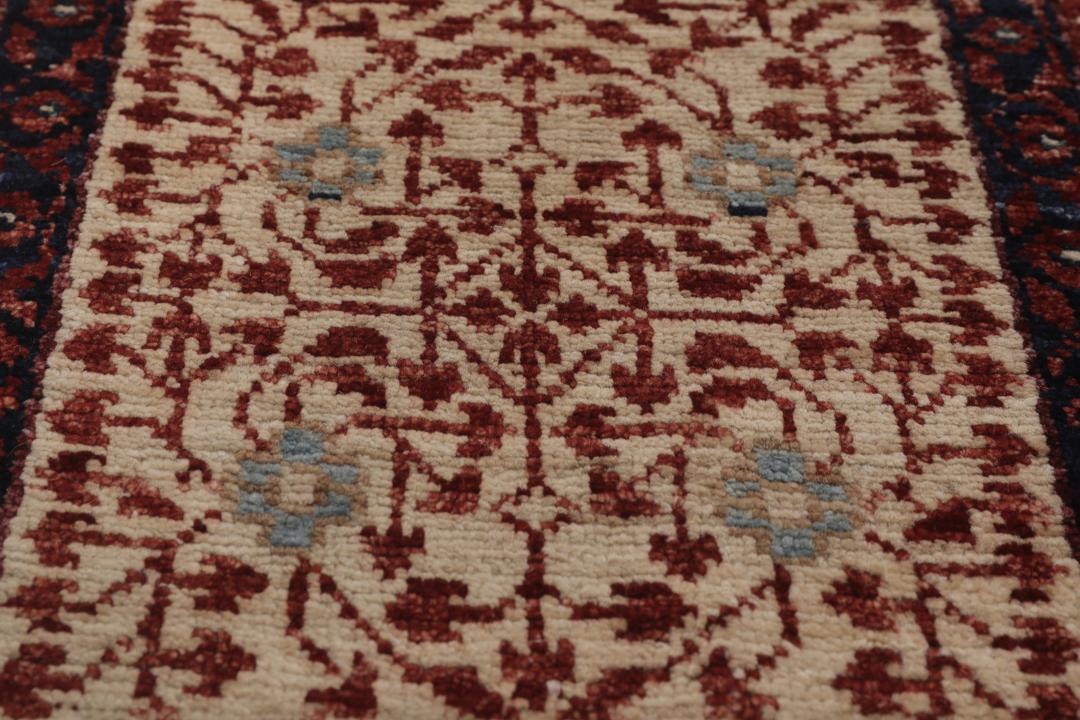 Et håndknyttet Mamluk-tæppe fra Afghanistan i røde og beige nuancer.